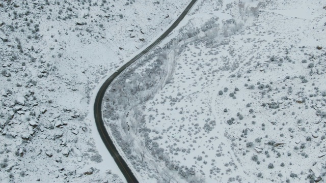 无人机拍摄的是一辆汽车在雪地里行驶的画面视频素材