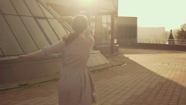 穿着礼服的漂亮女孩在日落的户外慢动作跳舞视频素材