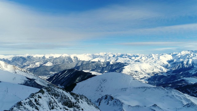 鸟瞰冬日雪山，蓝天下令人叹为观止的自然景观。法国的山顶被雪覆盖着。冬天令人放松的白色风景。视频素材