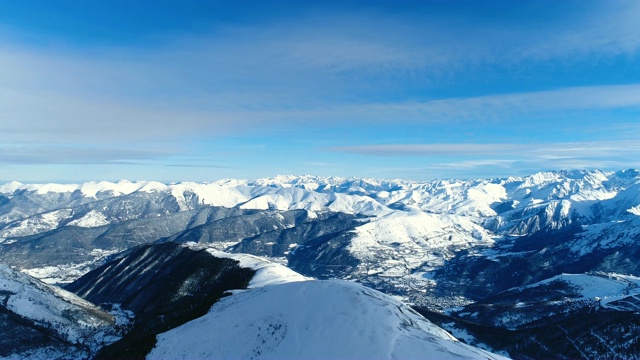 空中拍摄的雪山山峰在一个晴朗的日子在欧洲。法国的山顶被雪覆盖着。冬天令人放松的白色风景。视频素材