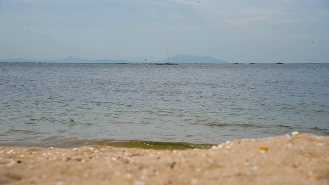 海模糊抽象宁静的海滩风景，泡沫的海浪在海滩上。白色泡沫的海浪与蓝色的海洋，热带海洋的沙子和阳光。旅游度假的海边。视频素材