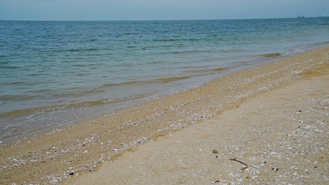 海模糊抽象宁静的海滩风景，泡沫的海浪在海滩上。白色泡沫的海浪与蓝色的海洋，热带海洋的沙子和阳光。旅游度假的海边。视频素材