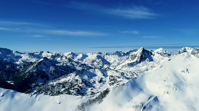 鸟瞰图的森林在雪山山脉在一个晴朗的日子。法国的山顶被雪覆盖着。冬季的白色风景令人放松，非常适合冬季运动。视频素材