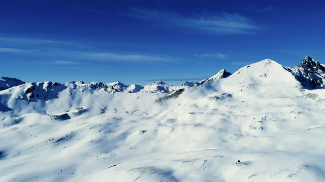 鸟瞰图在一个晴朗的日子雪山山脉。法国的山顶被雪覆盖着。冬天令人放松的白色风景。视频素材