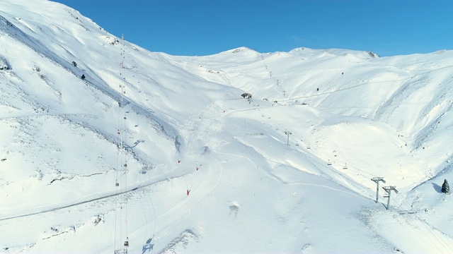 雪山滑雪场滑雪者的鸟瞰图。冬季滑雪和单板滑雪的好天气。视频素材