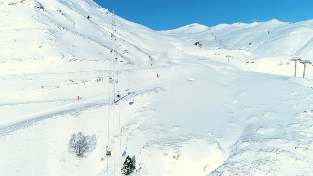 鸟瞰图在滑雪胜地滑雪缆车，在雪山。冬季滑雪和单板滑雪的好天气。视频素材