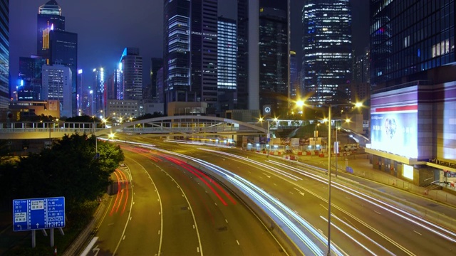 (向上倾斜)夜间的交通延时和香港摩天大楼的城市景观。视频素材