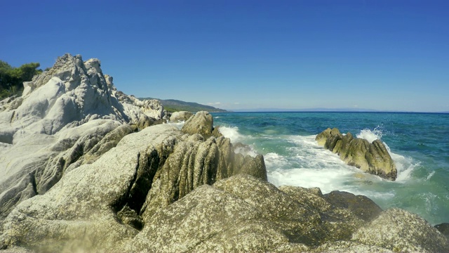 蓝色的海浪冲击着岩石的海岸线视频素材