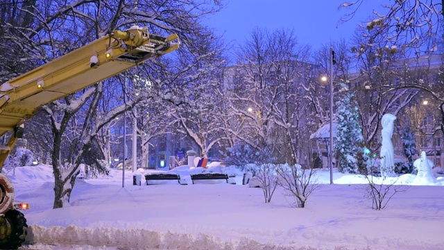 特写专用扫雪机将雪卸载到卡车上。雪在户外犁。视频素材