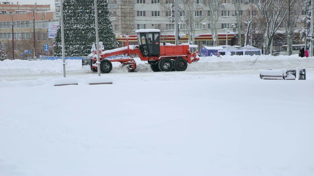 挖掘机清理城市街道上的大量积雪。视频素材