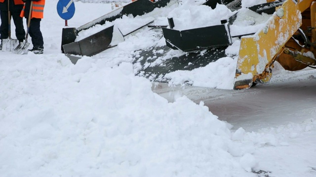 挖掘机清理城市街道上的大量积雪。视频素材