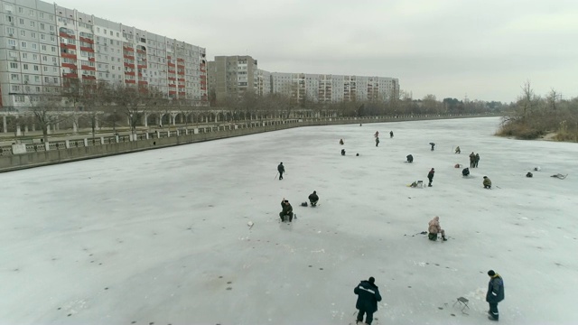 鸟瞰图的河流，渔民在冰上。多云的冬日。乌克兰Energodar, 4K视频视频下载