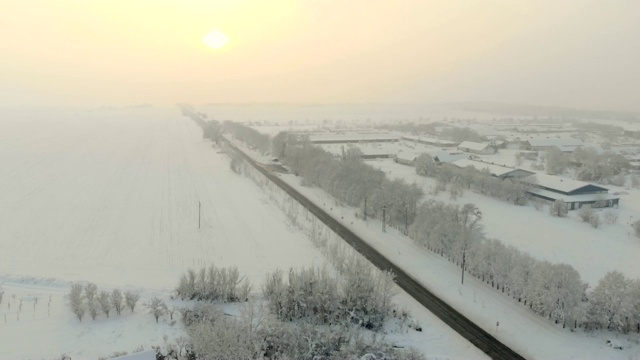 用无人机4K航拍白雪覆盖的平原上的村庄。视频下载