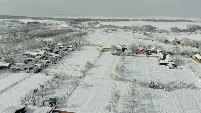 用无人机4K航拍白雪覆盖的平原上的村庄。视频下载