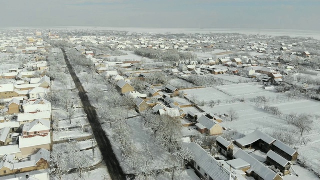 用无人机4K航拍白雪覆盖的平原上的村庄。视频下载