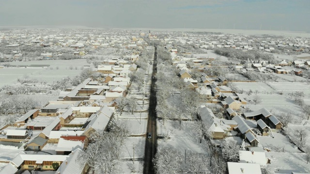 用无人机4K航拍白雪覆盖的平原上的村庄。视频下载