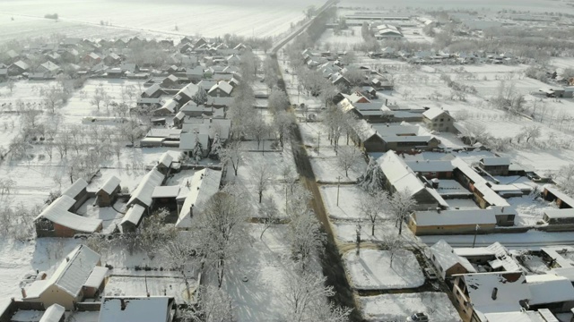 用无人机4K航拍白雪覆盖的平原上的村庄。视频下载