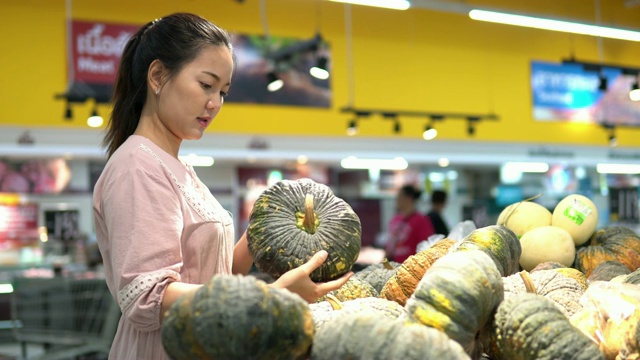 年轻女子在超市选择了水果和购物视频素材