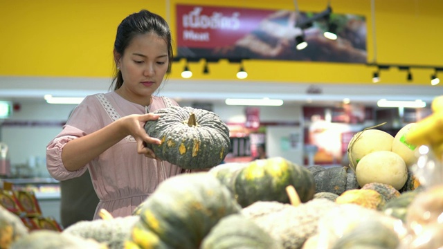 年轻女子在超市选择了水果和购物视频素材