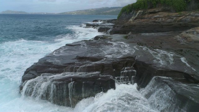 低角度鸟瞰海浪冲击悬崖和岩石，瓦胡岛，夏威夷视频素材