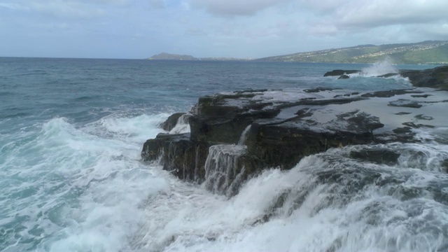 低角度鸟瞰海浪冲击悬崖和岩石，瓦胡岛，夏威夷视频素材