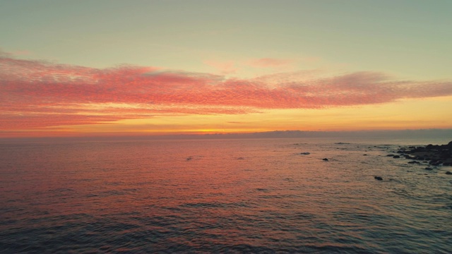 海浪上的日出。美丽的云景和岩石海滩，视频视频素材