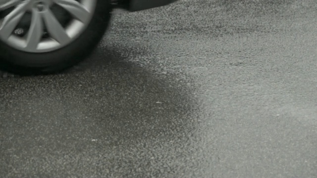 一辆汽车在洪水中被溅到。雨天在城市道路上行驶的汽车。缓慢的运动。视频素材