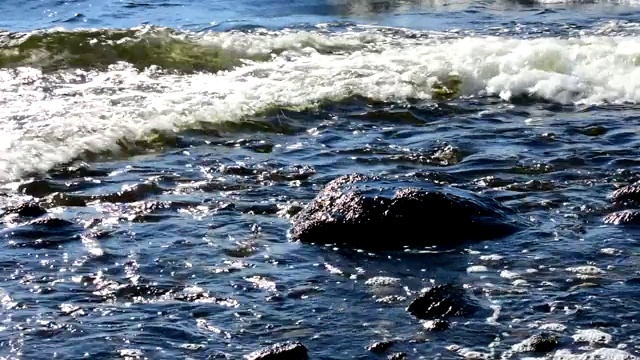 海水冲刷着海岸上的石头。视频下载