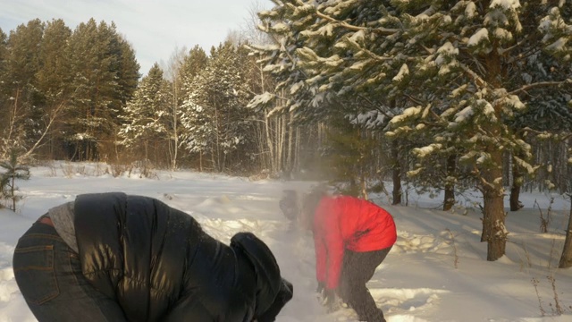 一对男女在冬天的雪地里玩打雪仗视频素材