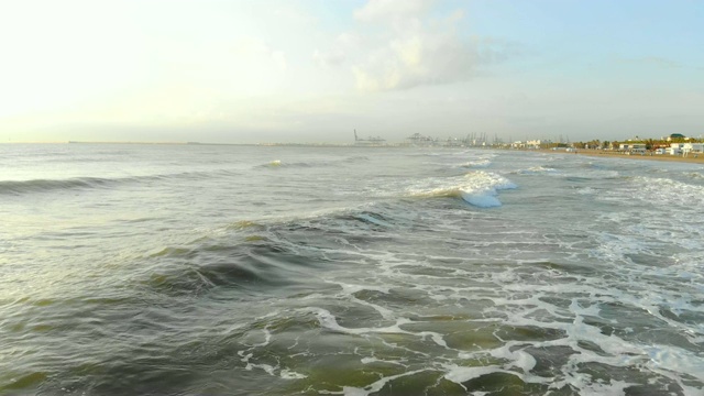 低空飞过向海岸的波浪。树荫下的波浪形成大量的泡沫和气泡。西班牙航空，地中海视频素材