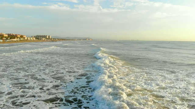 低空飞过向海岸的波浪。树荫下的波浪形成大量的泡沫和气泡。西班牙航空，地中海视频素材