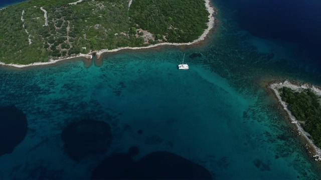 在地中海小岛附近抛锚的双体船鸟瞰图视频素材