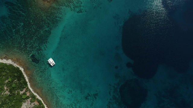 一艘双体船在地中海小岛附近直接抛锚视频素材