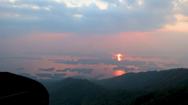 从泰国北碧山的山顶拍摄的白象山上蓬松的云和日落的时间流逝视频素材