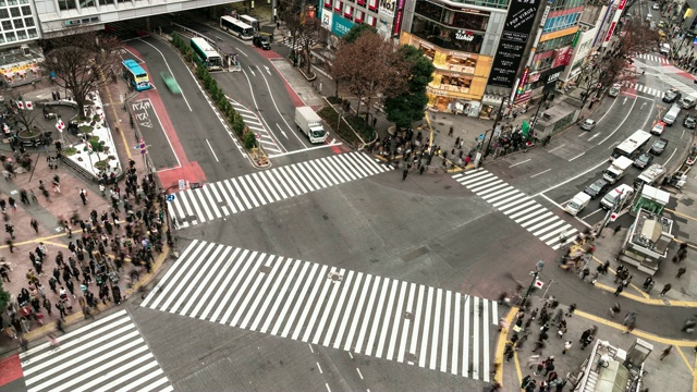 涉谷斑马线上拥挤的人群和汽车穿越十字路口的4K超高清航拍延时图。东京旅游景点地标，日本旅游，或亚洲城市生活理念视频素材