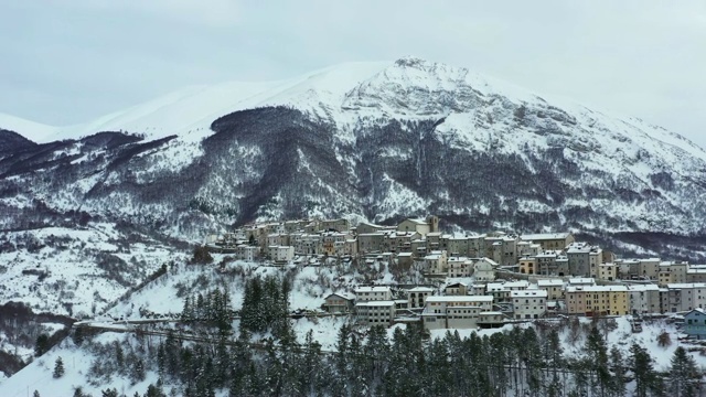 鸟瞰美丽的奥皮村，背景是雪山。奥皮是意大利中部阿布鲁佐地区拉奎拉省的一个公社和城镇。视频素材