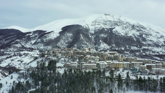 鸟瞰美丽的奥皮村，背景是雪山。奥皮是意大利中部阿布鲁佐地区拉奎拉省的一个公社和城镇。视频下载