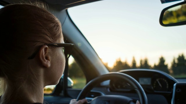 一个女人开着车行驶在空旷的乡村道路上视频素材