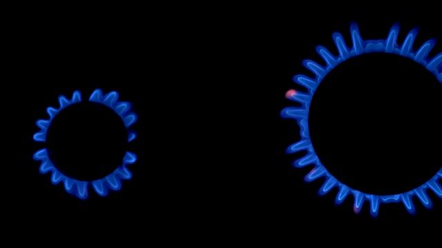 煤气炉的两块面板被蓝色的火焰慢慢点燃。蓝色和黄色的热火焰燃烧器在黑色的背景。慢动作视频素材