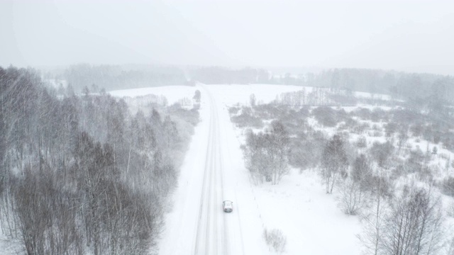 从空中俯瞰，三辆汽车在厚厚的雪道上行驶视频素材