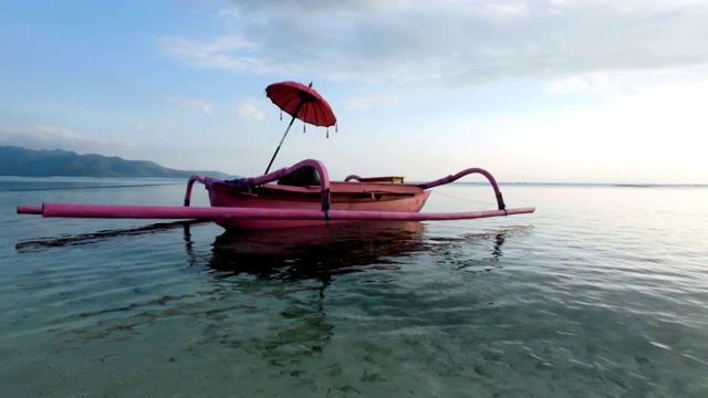 在巴厘岛的Gili Trawangan岛，女孩在一艘粉红色的船上晒太阳视频素材