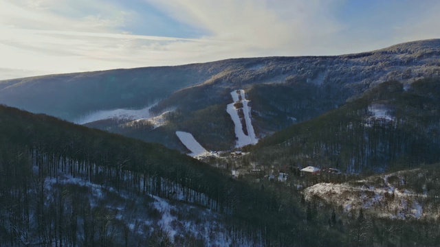 美丽的山在雪天雪村的背景下，冬天的乡村景观视频素材