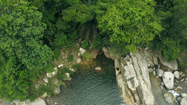 悬崖鸟瞰图上的热带森林和河流。湖在热带雨林中，热带树木和植物。无人机的观点，水流流动的山瀑布在丛林视频素材