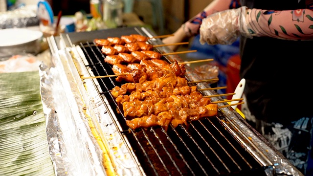 小贩烤泰国传统烤鸡串烧烤。泰国的街头食品。视频素材