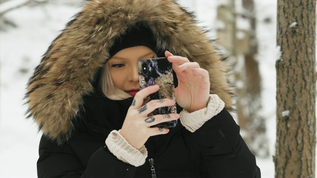 在大雪纷飞的冬日里，穿着舒适的皮大衣的漂亮年轻女人视频素材