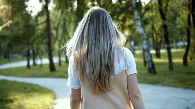 有魅力的女孩走在街上。风在女孩的头发上玩着慢动作视频素材