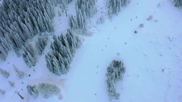 滑雪场雪山缆车上的鸟瞰图滑雪者和单板滑雪者。视频素材