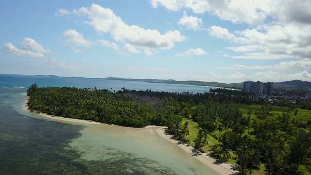 空中俯瞰热带僻静的海滩，远处有高层酒店视频素材