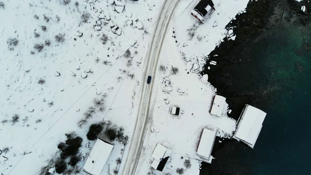 在冬季暴风雪中，汽车在靠近北极海岸线的道路上行驶的鸟瞰图视频素材