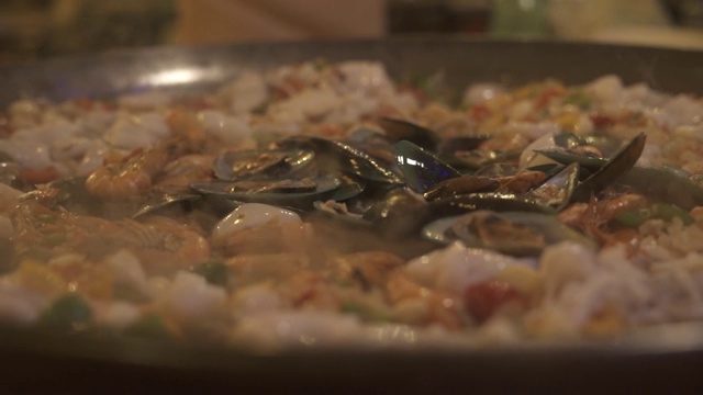 用平底锅烹煮贻贝、虾及鱿鱼。西班牙餐厅厨师准备海鲜饭。烹饪食物的概念。传统的西班牙烹饪视频素材